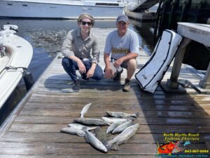 North Myrtle Beach Fishing Charterts two men on the dock nailing down in front of speckled sea trout on a inshore fishing charters in March with North Myrtle Beach Fishing Charters