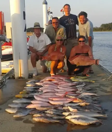 people on the dock with fish in front of them that they caught on a deep sea fishing charters in Myrtle Beach