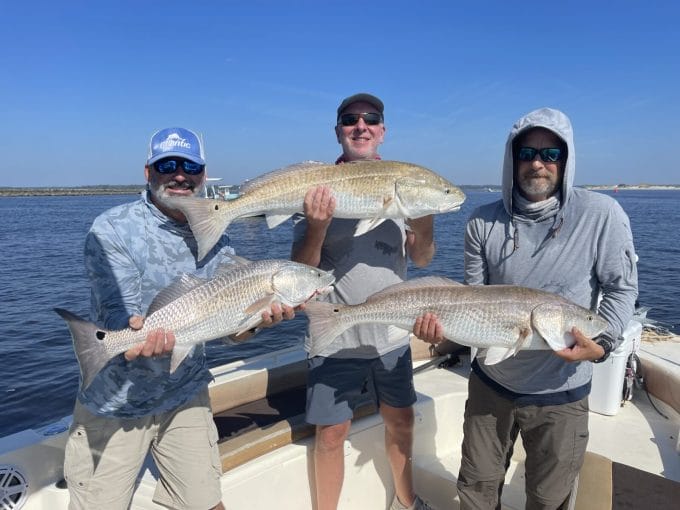 Group holding a redfish on a private inshore fishing charter near Myrtle Beach